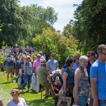 People queuing in a garden for Antiques Roadshow